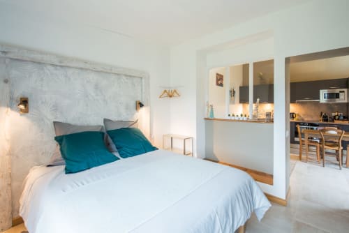 Chambre lumineuse au Château de la Malmaison, cottage L'atelier de Perrine en Champagne avec coussins bleu-vert, tête de lit en bois