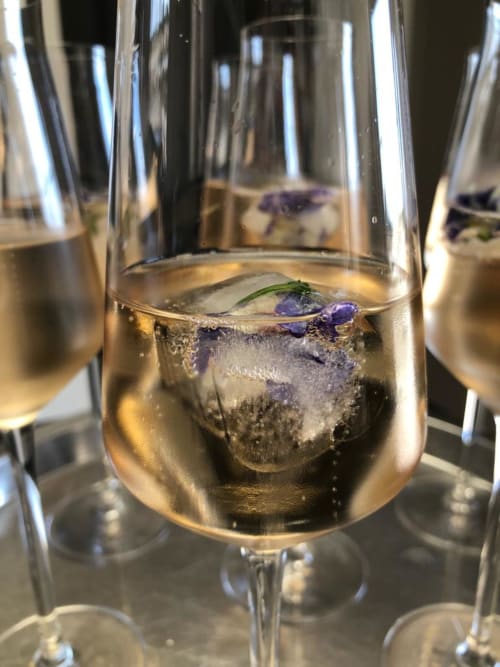 Ein Glass Crémant und Blumen Eiswürfel