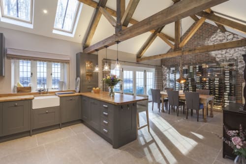 Luxury kitchen and dining area at Three Little Pigs cottage in Blandford Forum with exposed beams, island, and modern