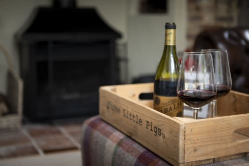Wine bottle and glasses in wooden Three Little Pigs crate at luxury cottage in Blandford Forum