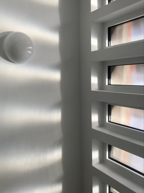 Chambre contemporaine au Gîte Moderne à Dunkerque avec fenêtres superposées, conduit de ventilation et vue sur la ville depuis le balcon