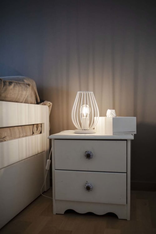 Lampe de chevet sur table de nuit blanche à côté du lit à la Résidence Le Roc Fleuri, Saint Malo