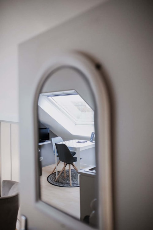 Porche cintrée menant à l'espace de travail de l'appartement à la Résidence Le Roc Fleuri à Saint-Malo, bureau et chaise visibles par l'ouverture