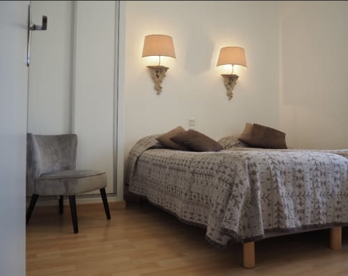 Chambre moderne à la Résidence Le Roc Fleuri avec lit, appliques murales décoratives et coin salon à Saint-Malo
