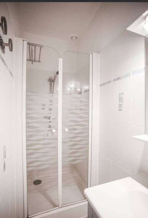 Douche spacieuse aux portes vitrées et carrelage ondulé à la Résidence Le Roc Fleuri, Saint-Malo