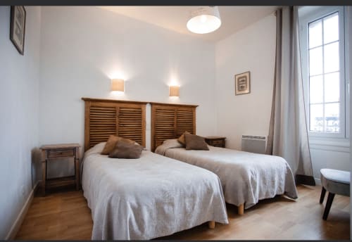 Chambre twin à la Résidence Le Roc Fleuri à Saint-Malo avec têtes de lit en bois, vue sur mer et équipements modernes