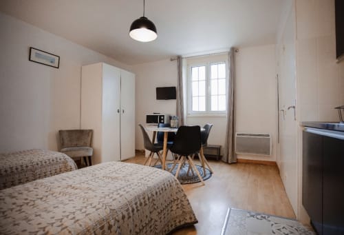 Lits jumeaux dans un appartement lumineux à la Résidence Le Roc Fleuri, Saint-Malo avec bureau, télévision et vue sur le jardin