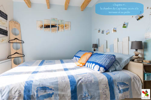 Chambre lumineuse au gîte Le Pirate Benèze à Trizay : literie bleu et blanc, poutres apparentes, décoration côtière