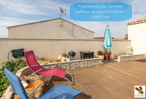 Terrasse ensoleillée du Pirate Benèze avec transats, barbecue et parasol à Trizay