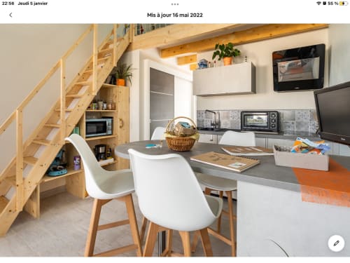 Cuisine moderne et coin repas au gîte Le Pirate Benèze à Trizay avec escalier bois, chaises blanches et aménagement compact