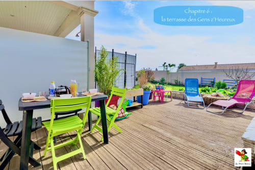 Terrasse colorée du Pirate Benèze à Trizay avec mobilier lumineux, terrasse en bois et espace de détente partagé