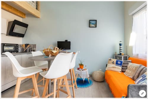 Studio cosy au Pirate Benèze avec kitchenette, table à manger, canapé orange, TV et vue sur jardin à Trizay