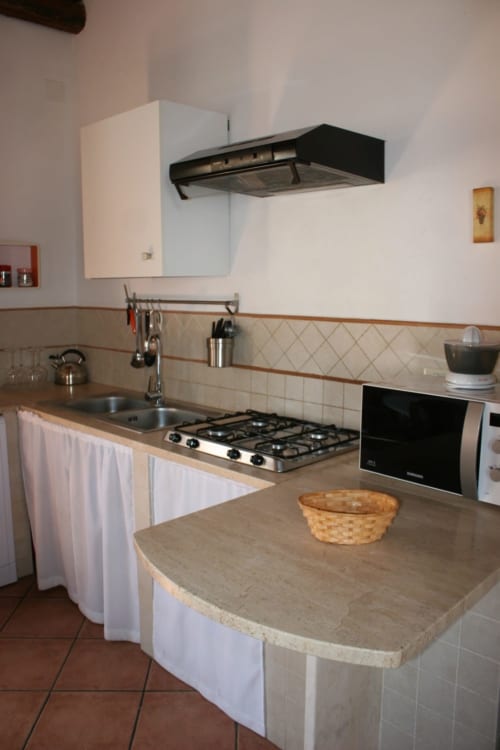 Modern kitchen in Casa Bellini Attico Apartment, Palermo, with gas cooktop, sink, and island counter