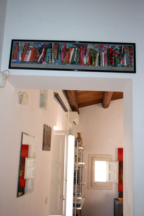Casa Bellini Attico apartment hallway in Palermo with exposed wooden beams and colorful framed artwork above doorway