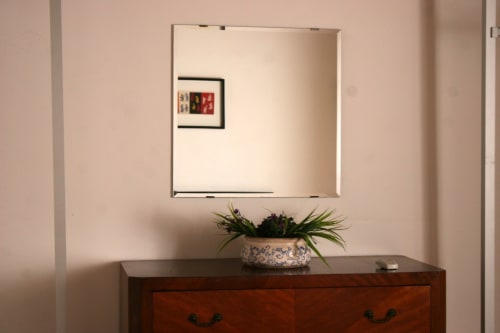 Mirror above wooden dresser with potted plant in Attico Apartment at Casa Bellini, Palermo
