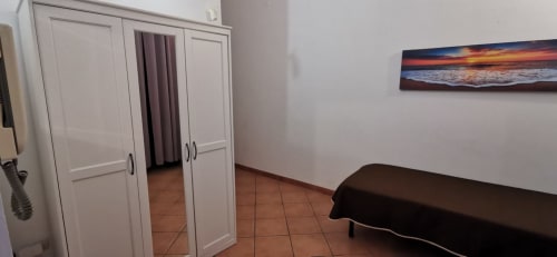 Bedroom at Casa Bellini Primo Apartment in Palermo with wardrobe, terracotta tiles, and sunset wall art