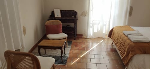 Relaxing seating area in the Colline guest room at Le Rêve d’Alice with wooden chairs and natural light