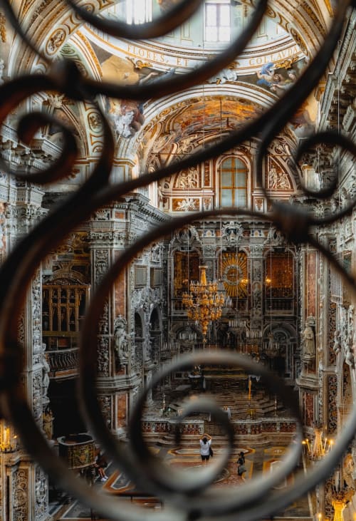 Ornate Baroque chapel interior at Casa Bellini B&B, Palermo, viewed through decorative iron grille