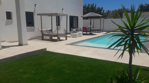 Villa moderne avec piscine turquoise, espaces détente, pelouse impeccable et plantes tropicales à A Vida é Linda, Santa Luzia