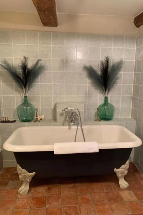 Schwarze Badewanne mit Klauenfüßen und grünen Dekorationsversen im La Bouscatière B&B, Moustiers-Sainte-Marie