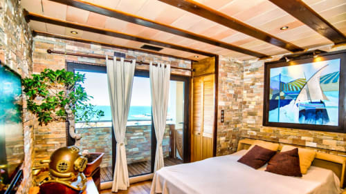 Luxurious beachfront bedroom in Banyuls-sur-Mer with sea views, stone walls, and modern amenities