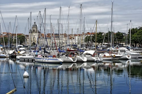 Voiliers amarrés au port de Trizay avec bâtiments historiques du front de mer, Le Pirate Benèze à proximité