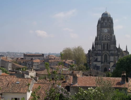Tour d'église médiévale surplombant les toits en terre cuite de Trizay, France près du Pirate Benèze