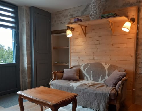 Studio douillet à La Maison De Fleurat avec mur en bois, canapé, ambiance tamisée et mobilier d'époque à Domeyrot