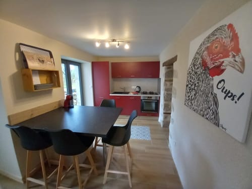 Cuisine et salle à manger modernes à La Maison De Fleurat, Domeyrot, avec meubles rouges et décor de coq.