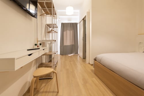 Modern bedroom at B&B La Camia with wooden bed, desk, shelving, and garden view in Castel di Sangro, Italy