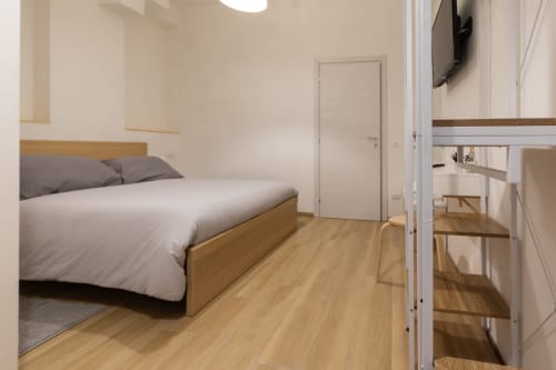 Matrimonial bedroom at B&B La Camia in Castel di Sangro with wooden bed, white linens, and hardwood floors