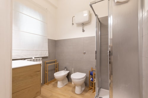 Modern bathroom at B&B La Camia Castel di Sangro with shower, toilet, bidet, and wooden furnishings
