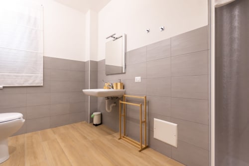 Accessible bathroom at B&B La Camia in Castel di Sangro with grab bars, wooden flooring, and modern fixtures