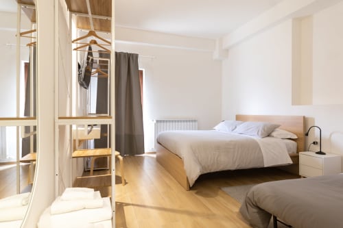 Bright modern bedroom at B&B La Camia in Castel di Sangro with wooden bed, wardrobe, and garden view