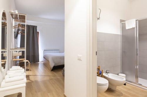 Triple room with ensuite bathroom at B&B La Camia in Castel di Sangro, featuring bed, shower, and wooden flooring