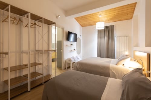 Triple bedroom with two beds, wooden wardrobe, TV, and modern amenities at B&B La Camia in Castel di Sangro