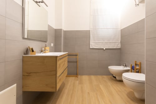 Modern private bathroom at B&B La Camia in Castel di Sangro with wooden vanity, toilet, bidet, and beige tiled walls