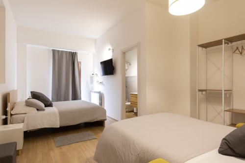 Bright quadruple room at B&B La Camia in Castel di Sangro with two beds, TV, and modern amenities