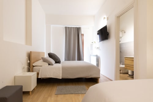 Bright quadruple bedroom at B&B La Camia in Castel di Sangro with twin beds, TV, and ensuite bathroom