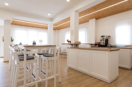 Modern kitchen and dining area at B&B La Camia in Castel di Sangro with white cabinetry and wooden beams