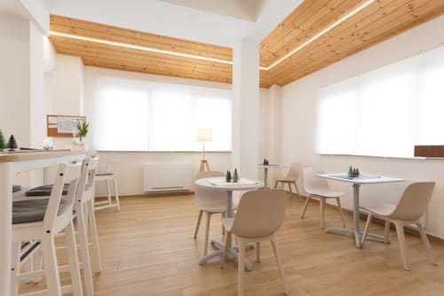 Modern B&B breakfast room at La Camia in Castel di Sangro with wooden beams, natural light, and contemporary seating areas
