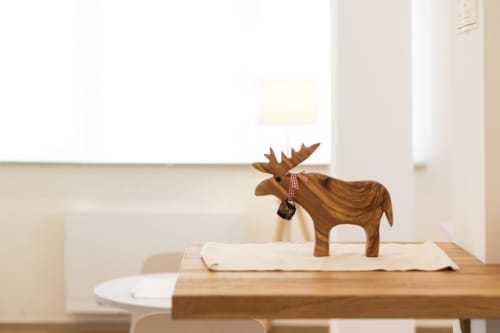 Wooden moose figurine with red scarf on table at B&B La Camia in Castel di Sangro, Italy