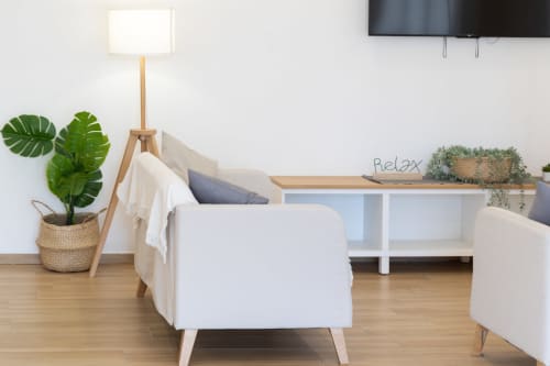 Modern relaxation room at B&B La Camia in Castel di Sangro with white furniture, plants, and wooden floor