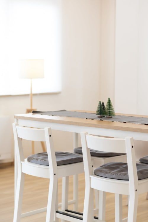 Modern dining area at B&B La Camia in Castel di Sangro with white chairs, wooden table, and minimalist decor