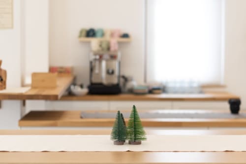 Minimalist desk workspace at B&B La Camia with decorative pine trees and wooden shelving in Castel di Sangro