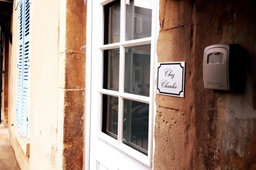 Entrée de l'appartement Chez Charles à la Conciergerie Des Climats à Beaune, avec fenêtre à cadre blanc et brique patinée