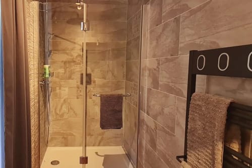Salle de bain moderne avec douche à l'italienne, paroi en verre et carrelage en marbre à la Conciergerie Des Climats à Beaune