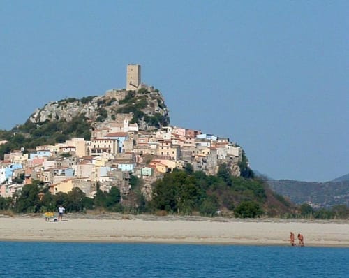 Posada medieval village on rocky hilltop with sandy beach and turquoise sea, Sardinia Italy