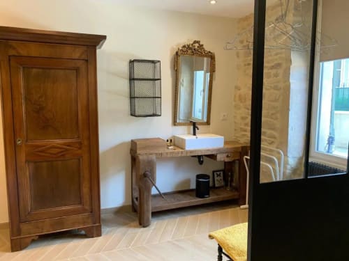 Salle de bains élégante à la Conciergerie Des Climats à Beaune avec meuble vasque en bois, lavabo blanc, miroir et douche