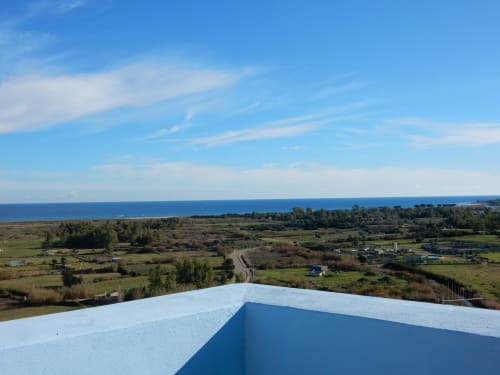 Vista costiera dal B&B Eleonora D'Arborea a Posada con mare, campi coltivati e cielo azzurro